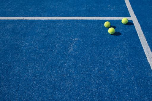 A view of three tennis balls on a blue court