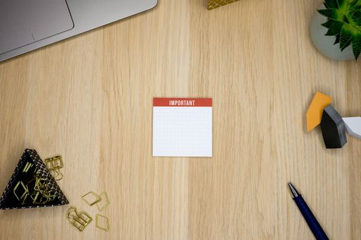 A top view of a notepad for important notes on a cluttered office desk