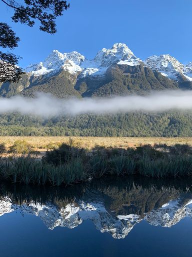 A vertical shot of snowy mountain range reflecting on the lake
