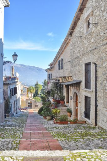 A beautiful view of a narrow street with plants and flowers in the village town of Veroli in Italy
