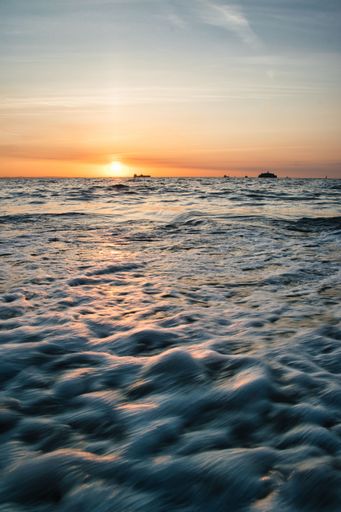 A vertical shot of calm sea waves during a beautiful sunset - great for backgrounds
