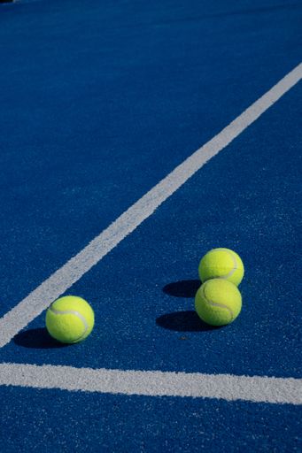 Selective focus. Three balls an the net of a paddle tennis court