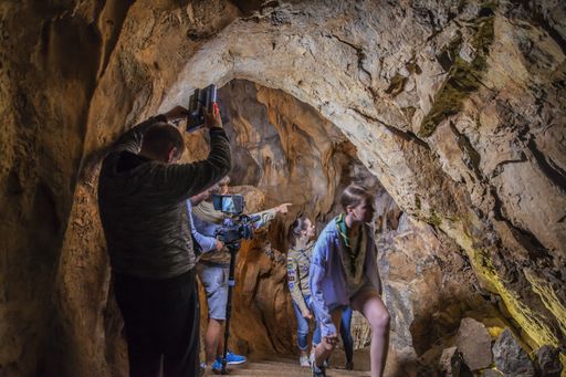 Scouts are exploring this cave and the leader is teaching them about Karst.