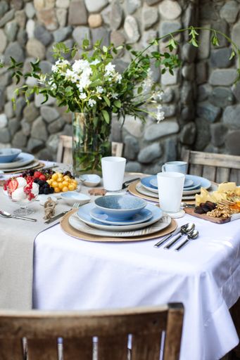 A vertical shot of tableware  with fruits and flowers in the cafe
