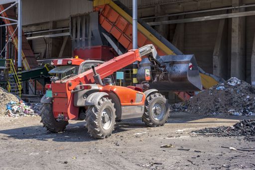 A front loader transporting industrial and communal waste materials in the waste treatment plant