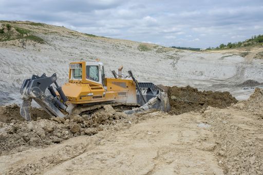 A bulldozer moving soil and rocks at a construction site