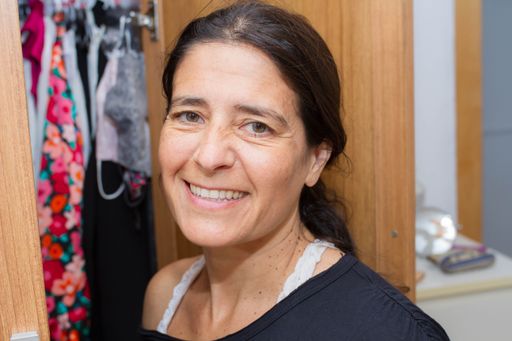 A portrait of a middle-aged Hispanic female looking, smiling to the camera