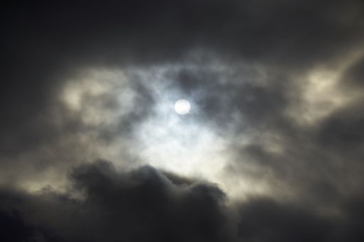 A beautiful shot of a full moon in the cloudy sky