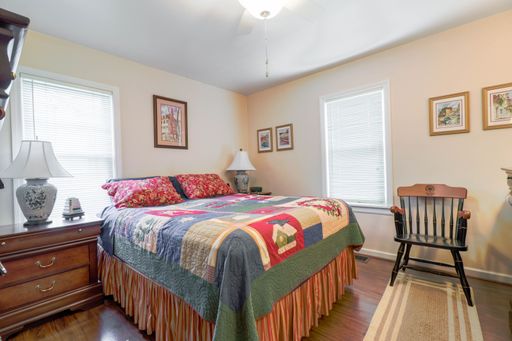 An interior of a bedroom with a double bed covered with a colorful blanket
