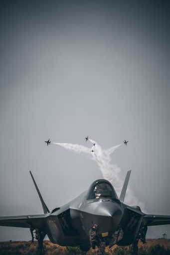A fighter jet in the background of other flying military aircrafts at Holloman AFB Air Show, NM, USA