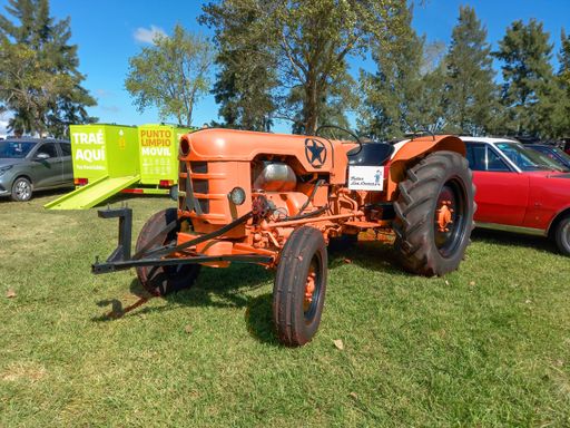 Old orange Deutz Fahr agricultural tractor 1950s or 1960s in the countryside. Nature grass trees. Classic car show. Copyspace