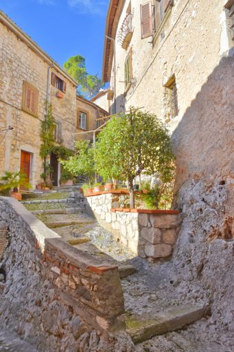 A narrow street with old buildings and plants in Veroli town in the Lazio region of Italy