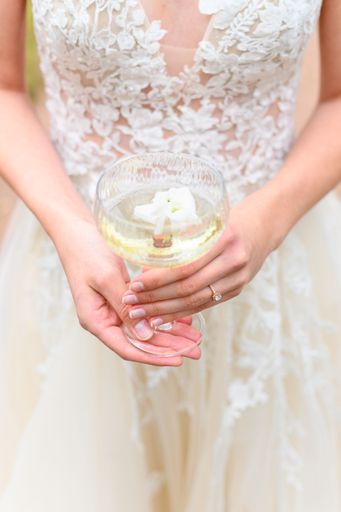 A vertical closeup of a Caucasian bride holding a glass of champagne in Florence, Tuscany