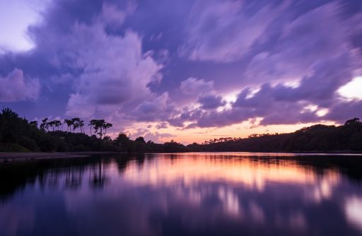 A breathtaking scenery of the sunset clouds reflecting in Lac du Jaunay, France