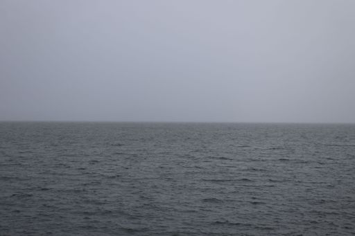 A beautiful view of the ocean surface with ripples on stormy ocean horizon under the cloudy sky