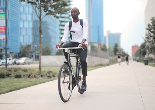 A young black male riding a bicycle on the street - healthy lifestyle concept