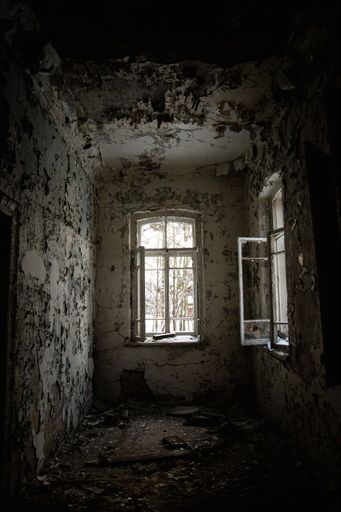 A vertical shot of an abandoned old broken building interior