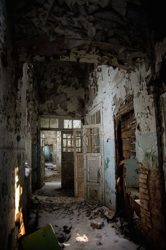 A vertical shot of an abandoned old broken building interior