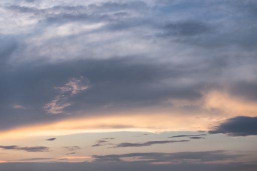 A low angle shot of the breathtaking clouds in the colorful sky captured at sunset