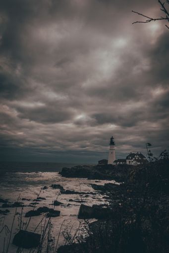 A vertical shot of Portland Head Light against the cloudy sky. Maine, United States.