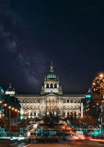 A vertical shot of a medieval palace in the city under the sky full of stars