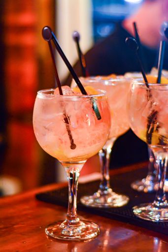 A vertical closeup of cocktails decorated with straw