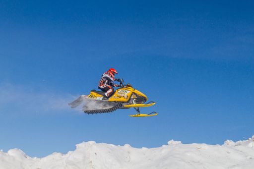 Snowmobile competing in extreme sports. Snowmobile jumps above the track. On a snowmobile, a sportsman.  Motorsports in the snow