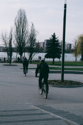 A vertical shot of people riding bicycles in city park
