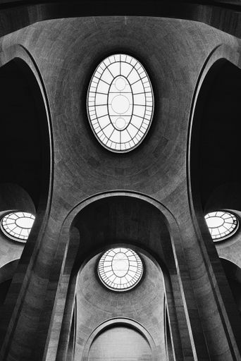 A low angle grayscale of the ceiling details of the famous Louvre Museum