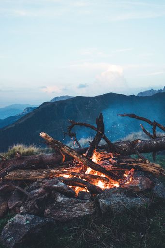 A vertical shot of a bonfire in the mountains