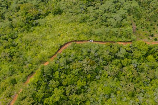 Aerial Shot View of Truck Driving Up to the Winding Road of Mountain Top in the Countryside of the Philippines. Green Forest and Nature Background.