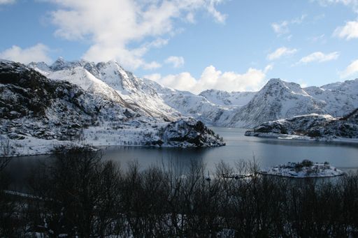 A mountain near the river is covered with snow in winter