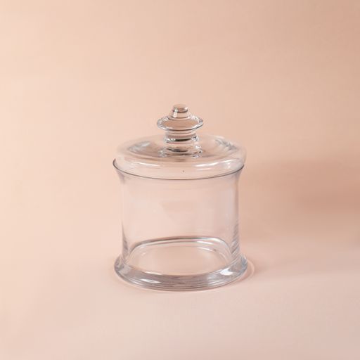 A glass sweets jar on a beige background