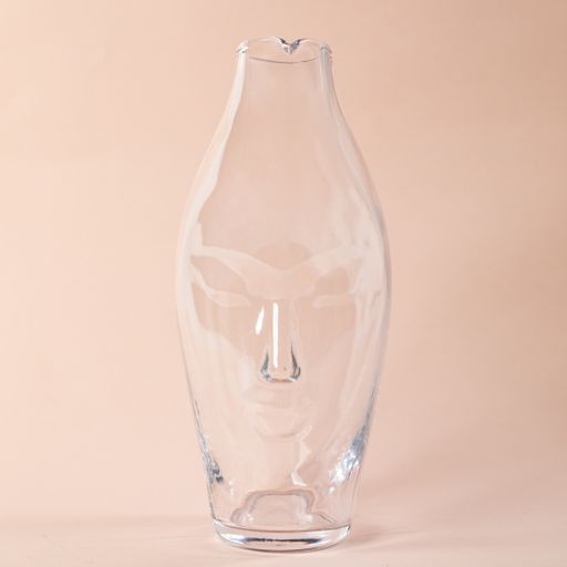 A closeup shot of a decorative glass vase for holding flowers on a light pink background