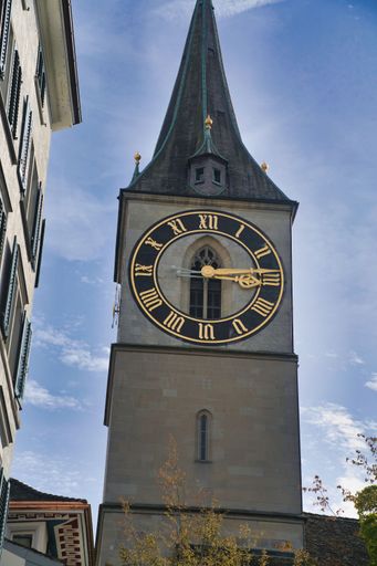 A vertical shot of a steeple of St. Peter Church with tower clock in Zurich, Switzerland
