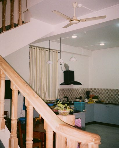 A vertical shot of a kitchen of an apartment with wooden staircase