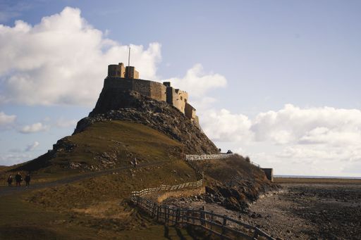 An aerial view of Lindisfarne castle in Holy Island surrounded by greenery fields