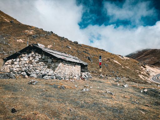 An old abandoned stone house on a mountain along a road