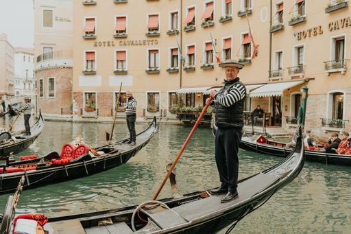 A beautiful shot of a gondolier on a gondola sailing in a canal in Venice, Italy