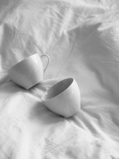 A shot of white tea cups in the bed