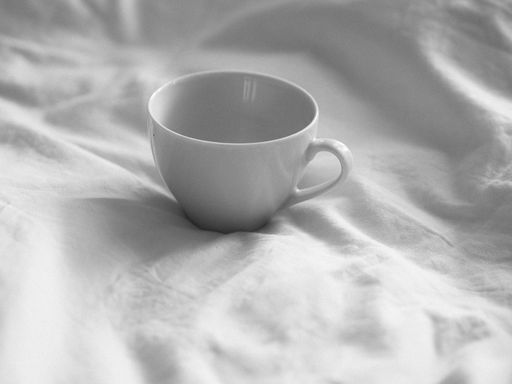 A shot of white tea cup in the bed