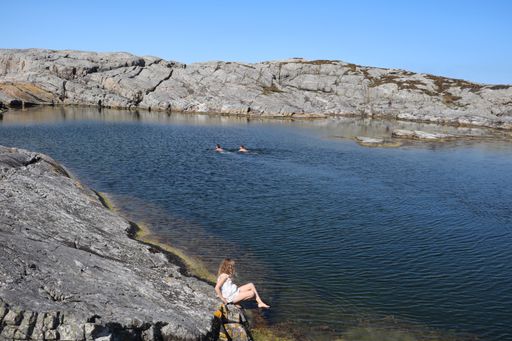 A scenic view of people bathing in a small lake in Oygarden, Western Norway.