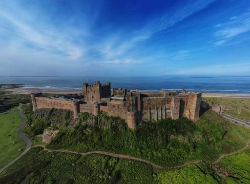 An aerial view of the Bamburgh Castle near the seashore in the UK