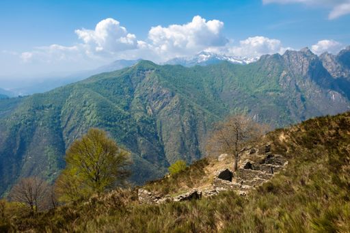 A view of grand mountains with ruins of historic structure on a sunny day