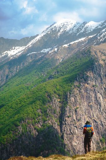 Vertical shot of a hiker looking  at the stuuning mountain landscape in the wild  Val Grande National Park,  Europe, Piedmont Italy