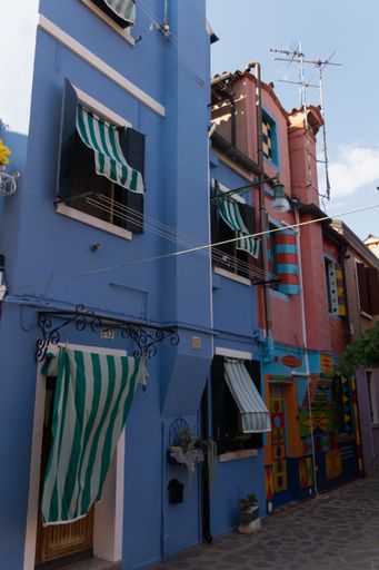 A vertical shot of colorful buildings along the streets of Venice in Italy during the daytime