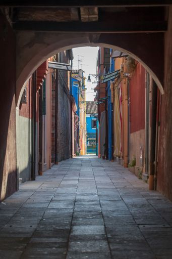 A vertical shot of colorful buildings along the streets of Venice in Italy through the arch