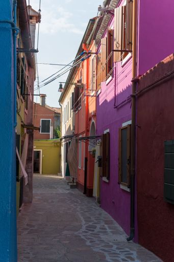 A vertical shot of beautiful colorful buildings along the street of Venice in Italy during the daytime