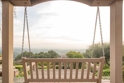 A wooden swing on a terrace with a beautiful view