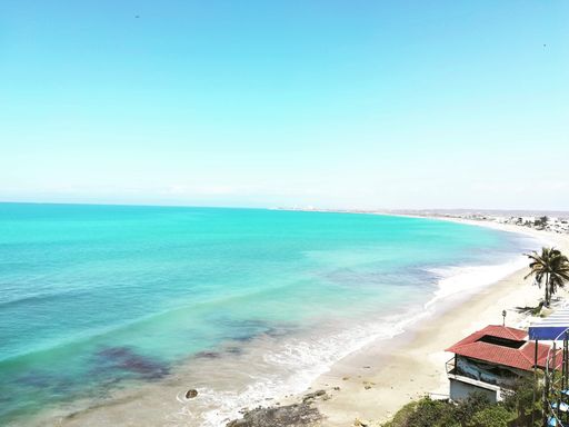 A beautiful view of a tropic sandy shore with small villas near the coastline